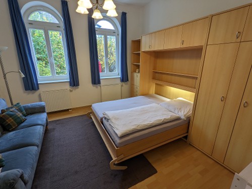 Wohnzimmer mit ausgeklapptem Schrankbett Wohnzimmer mit ausgeklapptem Schrankbett